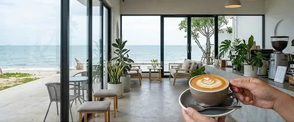 Modern Sahil Kafesi: Deniz manzaralı, şık ve minimalist bir kafe iç mekanı.